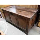 An antique carved and panelled oak coffer, 132 cm wide x 58 cm deep x 72 cm high