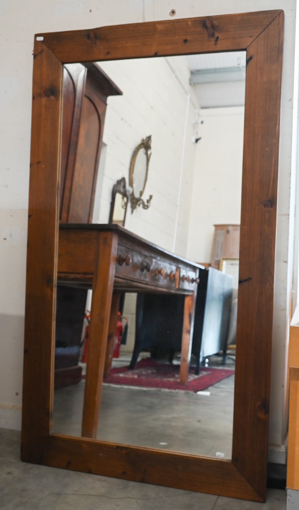 A large rectangular wall mirror in stained pine frame, 140 cm x 80 cm