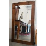 A large rectangular wall mirror in stained pine frame, 140 cm x 80 cm