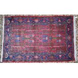 A Persian Hamadan rug, the geometric design on pale red/blue ground, 155 x 100 cm