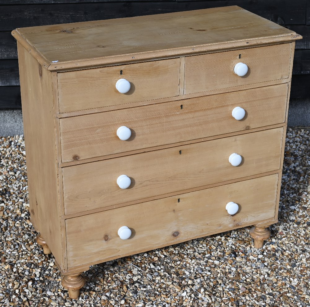 A waxed pine chest of two short over three long drawers with white crackle-glazed ceramic handles