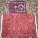 A red ground Tekke Bokhara rug with typical repeating gul design, 190 x 125 cm, to/w a Persian Heriz