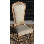 A Continental gilt framed nursing chair with repeating leaf pattern brocade upholstery