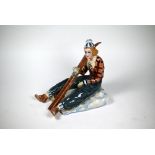 Nove (Venice) pottery figure of a lady skier, seated on the snow and holding her skis, modelled by