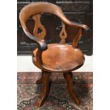 An antique elm seat swivel office armchair