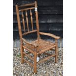 A rustic farmhouse elm armchair with wicker seat