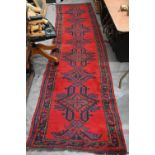 A vintage Turkish red ground runner with geometric design and repeating boteh border, 415 x 82 cm
