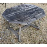 A weathered teak extending garden table to/w an armchair (2)