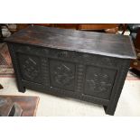 An antique oak coffer with lunette and foliate carved panelled front, 130 cm wide x 58 cm deep x