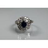 A sapphire and diamond cluster ring, the rectangular diamond cluster formed of two rows supporting a