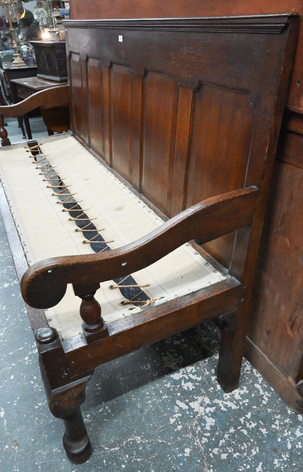 An 18th century oak panel backed settle, with shaped arms over a rope and canvas seat (cushion - Image 6 of 6