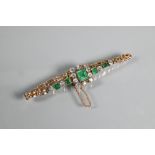 An emerald and diamond cluster bracelet, the central rectangular baguette cut emerald surrounded