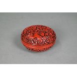 A 20th century Chinese cinnabar style circular box and cover, moulded with a floral and foliate