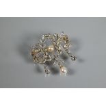 An Edwardian diamond and pearl brooch, the open design formed of leaf tendrils set with mixed cut