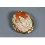 A large Victorian carved shell cameo brooch featuring maiden seated in a landscape, yellow metal