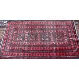 An old Persian soft-red ground rug, 2nd quarter 20th century, 190 cm x 105 cm