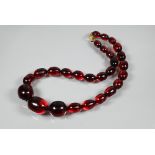 A row of graduated cherry amber beads, approx 72.6g, 2.5 x 2 cm the largest bead