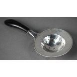 Danish unmarked white metal tea strainer with beaded rim and ebonised carved handle, 17cm long