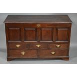 A George III oak mule chest, the wide plank hinged top over four fielded panels, three short and two