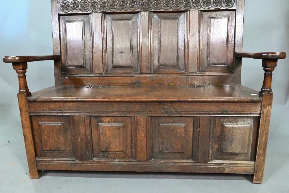 An antique oak box settle, the panelled back with floral carved rosette's over shaped arms and an - Image 6 of 6