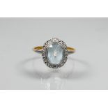 An oval pale aquamarine in yellow and white metal setting, size O