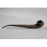 An antique Tibetan Buddhist ritual pipe with moulded clay bowl inserted into the long embossed