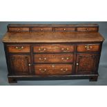 A 18th century oak low dresser, the two plank top with four drawer stage back, over an arrangement