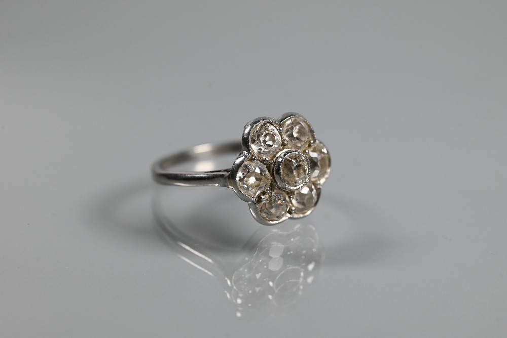 An antique diamond daisy cluster ring, the millgrain set central old cut diamond surrounded by six