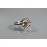 An antique diamond daisy cluster ring, the millgrain set central old cut diamond surrounded by six