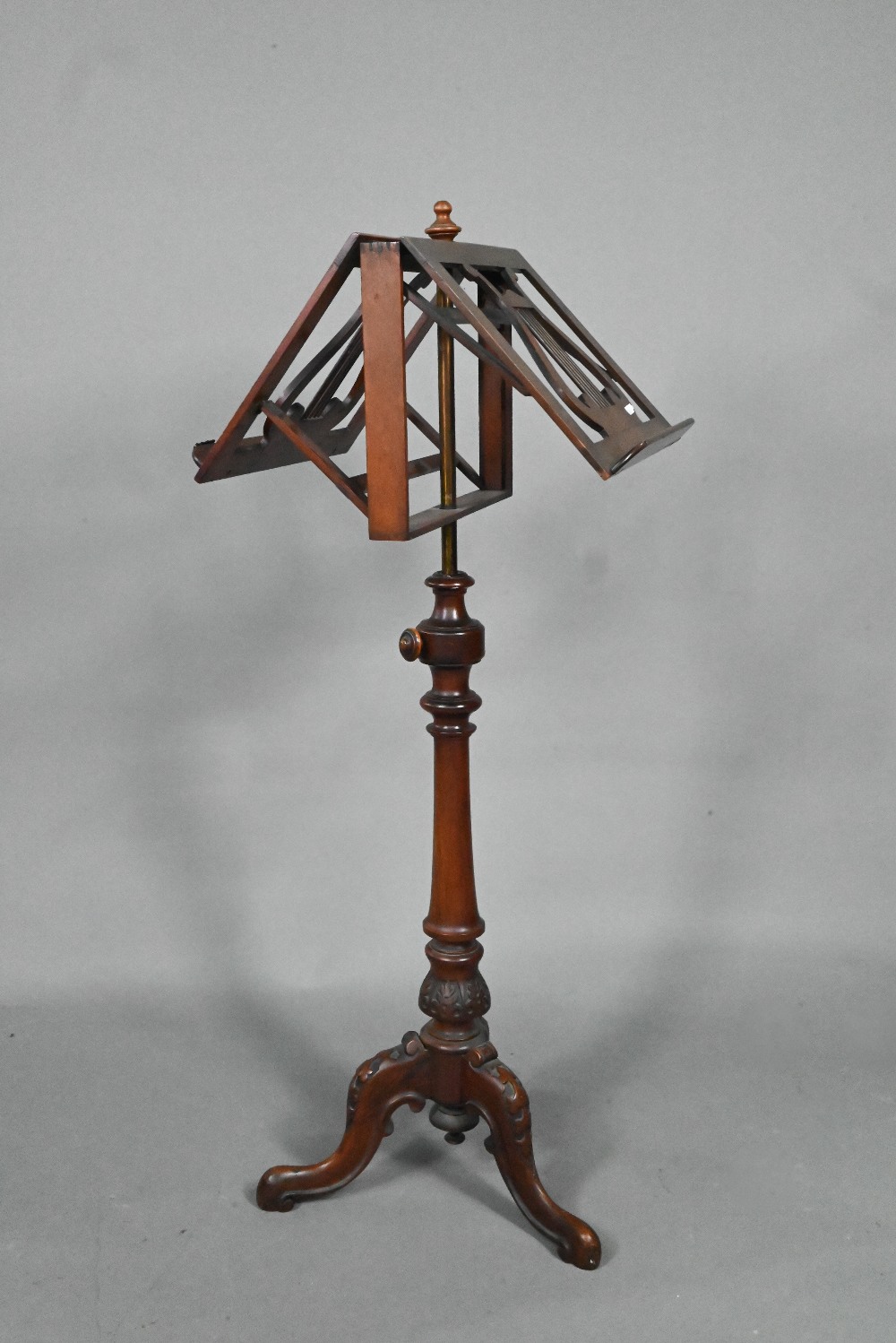 A Victorian mahogany duet music stand, the adjustable lyre centred easels raised on a brass pole