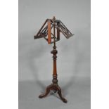 A Victorian mahogany duet music stand, the adjustable lyre centred easels raised on a brass pole