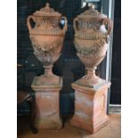 A large pair of weathered classical cast terracotta lidded urns, with twin loop handles and