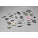 A collection of Victorian and later silver and white metal brooches, pendants and pins including