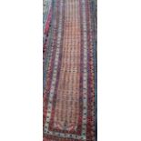 An antique Persian Hamadan runner, the pale red ground with repeating stylised floral design,