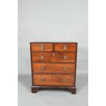 A Georgian mahogany diminutive chest of two short over three long graduated drawers, raised on