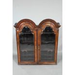 A William & Mary period walnut double dome top cabinet, with pair of arched glazed doors enclosing
