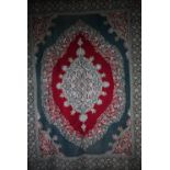 A large antique Kashmir crewel work carpet, first quarter 20th century, the soft red ground with