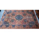 A good fine antique Persian Kashan rug, the rust-red ground centred by a blue ground medallion,