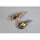 Two Art Nouveau pendants - one with flower and leaf tendril design set with two faceted amethysts,