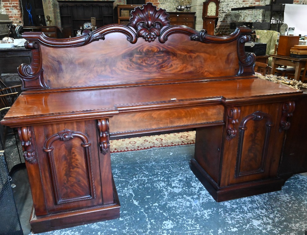 A large Victorian mahogany country house twin pedestal sideboard, the heavily moulded back over a