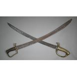 Two 19th century Naval cutlasses, with curved blades, cast brass hilt, the other with brass and