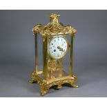 A gilt metal four window mantel clock, the 8-day two train drum movement with white enamelled