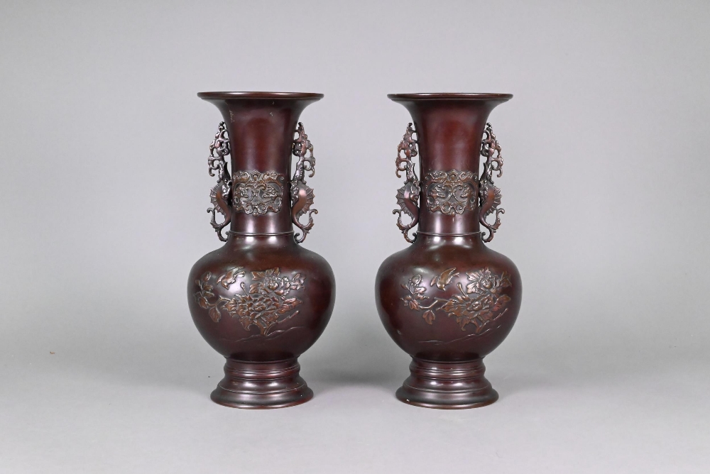 A pair of late 19th or early 20th century Japanese bronze vases, the flaring necks with archaistic