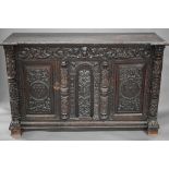 A large antique jointed, carved and applied carved moulded oak library cabinet in the Flemish style,