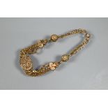 A Victorian 9ct rose gold bracelet formed of three chains linked by balls, and oval foliate engraved