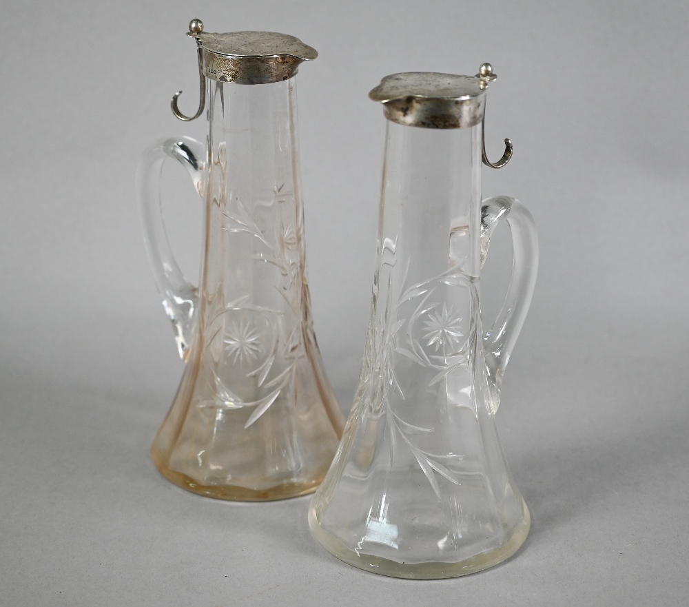 Pair of Edwardian cut glass claret jugs with flared bases and silver collars and covers with