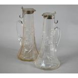 Pair of Edwardian cut glass claret jugs with flared bases and silver collars and covers with