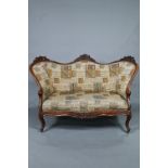A late Victorian oak double spoon back sofa, with Latin alphabet tapestry style fabric, raised on