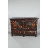 An antique Chinese red laquer and polychrome decorated two door cabinet, presented in distressed