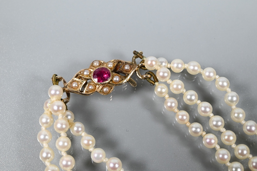 A triple row of graduated cultured pearls double knotted throughout onto ruby and pearl set snap, - Image 3 of 5